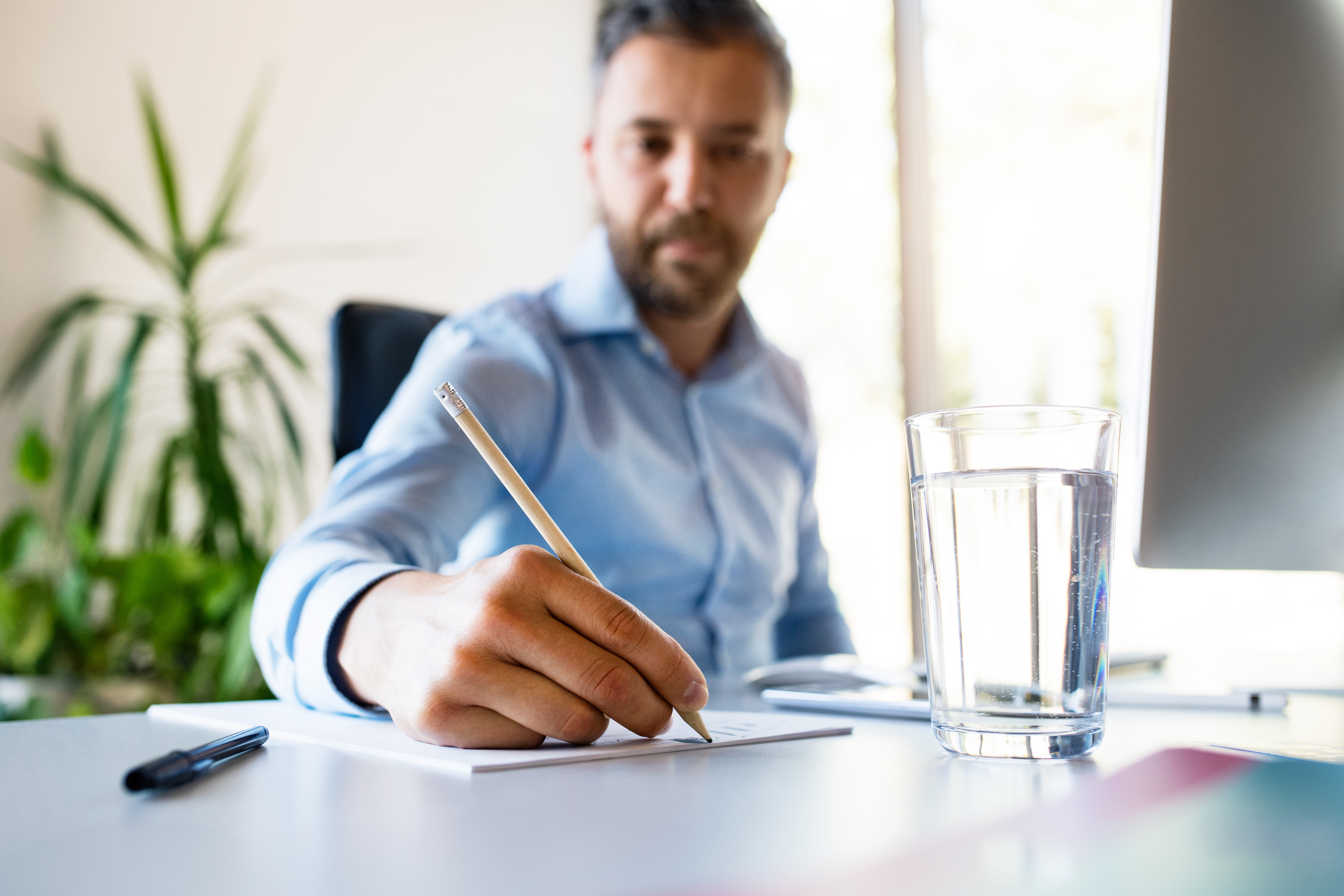 business man writing on paper at a desk