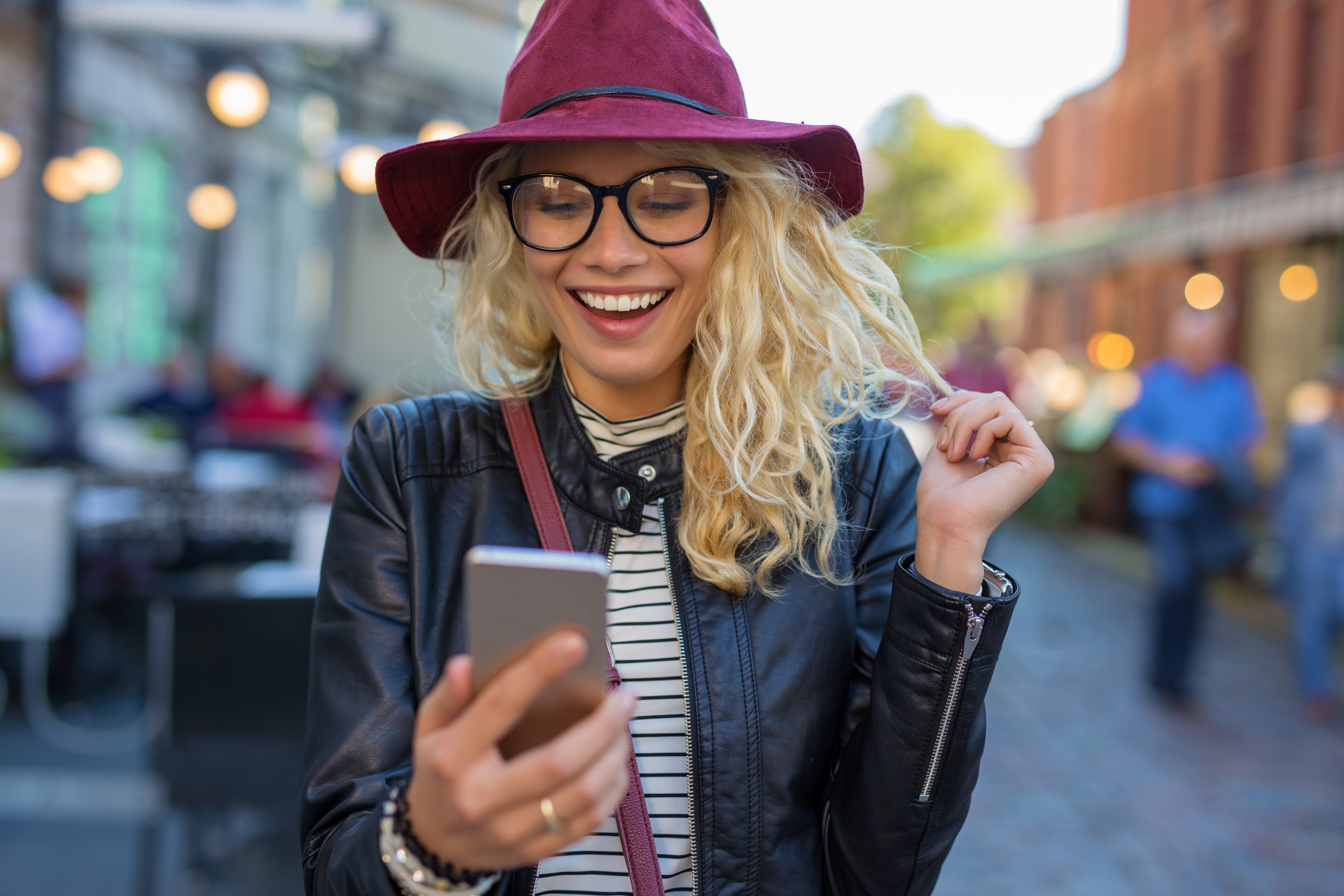 woman smiling at phone against city background