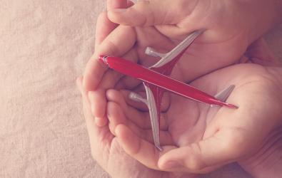 holding a miniature toy plane in hands