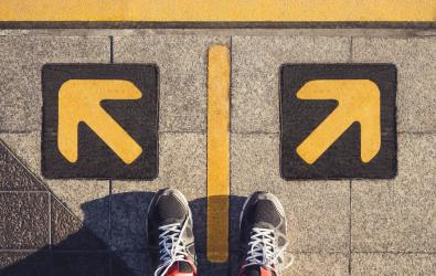 A pair of feet standing on a platform in front of a left and right directional arrow.