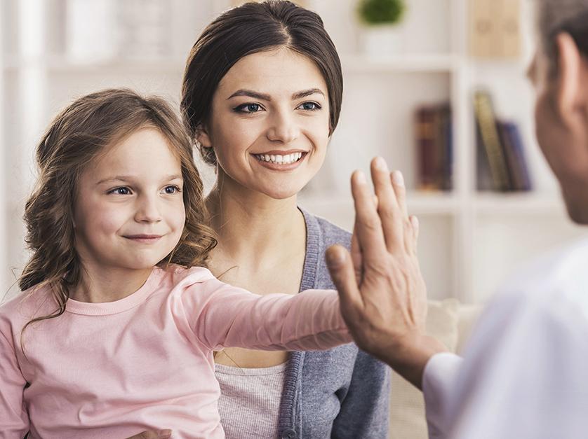 daughter and mother at the doctor, high fiving