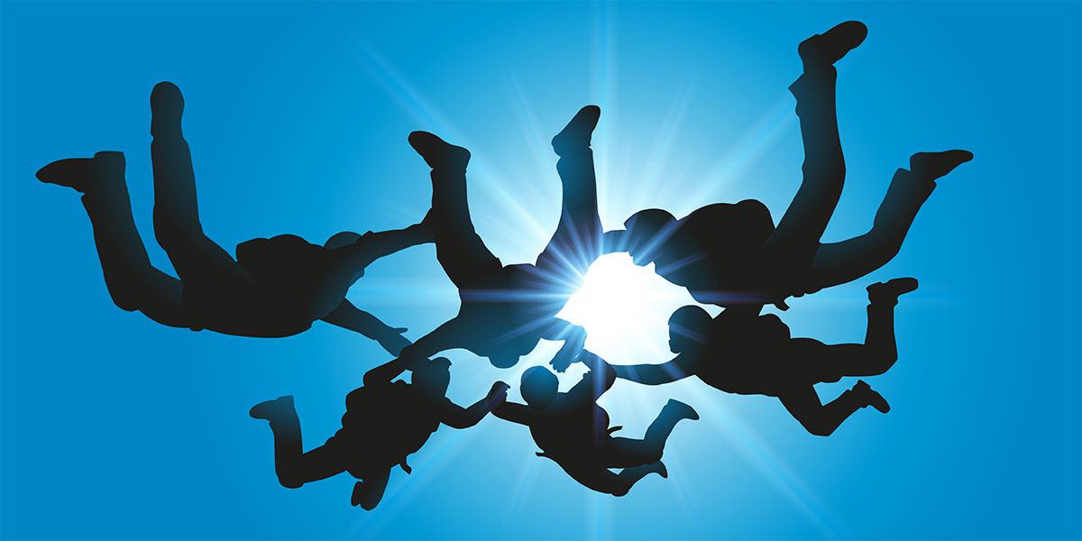 Six skydivers jumping in tandem.