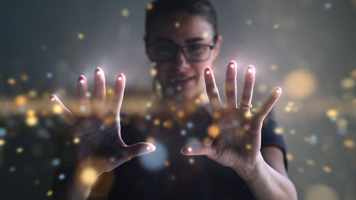 Woman holding up hands with points of light.